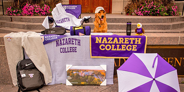 hat-wearing dog amid a collection of Naz swag in front of Golisano Academic Center
