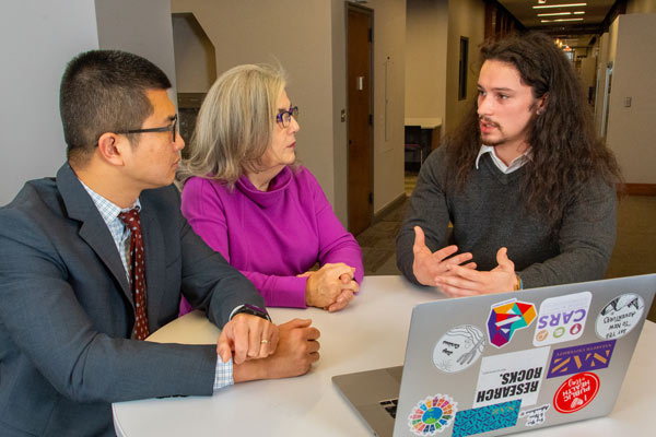 Student Ian Bankes meets with two public health faculty who guided him